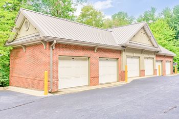 a garage with three garages and trees in the background